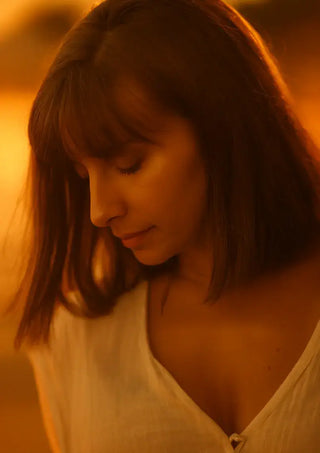 Portrait de femme pensive au coucher du soleil, illustrant la recherche d’un équilibre intérieur et de sérénité.