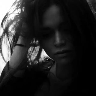 Femme fatiguée se tenant la tête entre les mains, symbolisant la surcharge mentale et la difficulté à gérer un rythme intense.