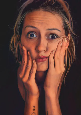 Femme détendue posant les mains sur sa poitrine, symbole d’apaisement intérieur et de relâchement de la mâchoire.